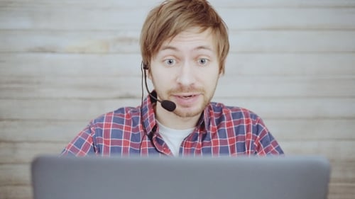 Positive Call Center Male Operator with Headset Talking with Client in Agency