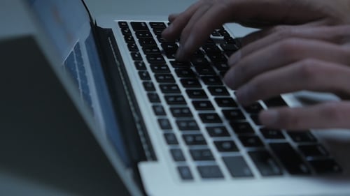 Hands typing on laptop keyboard for technology footage