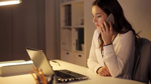 Woman with Laptop Calling on Smartphone at Office 11