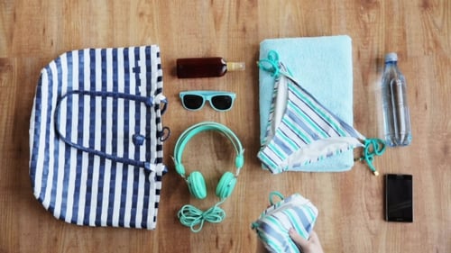 Hands Packing Beach Accessories To Bag 18