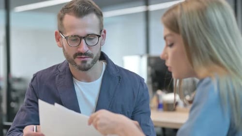 Male and Female Professionals Having Discussion with Documents