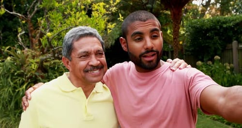 Father and Son Taking Selfie Together in Garden