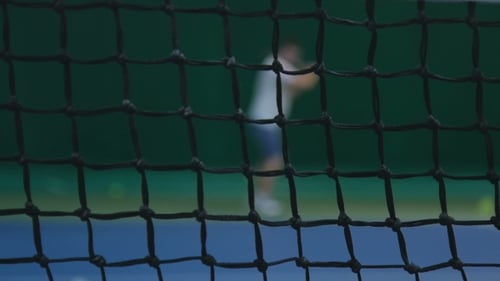 Tennis Player Hitting Ball Through Net Blurred View