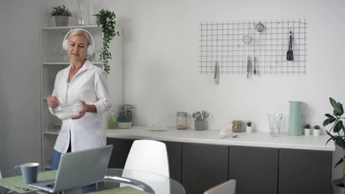 Woman in White Whisking in Bright Kitchen