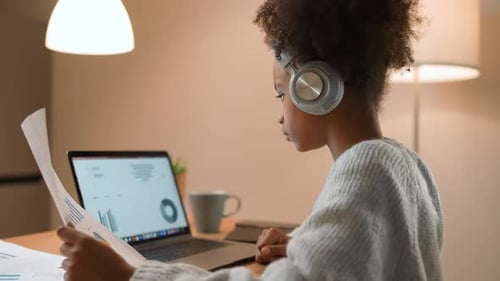 Young African Girl is Learning to Work with Financial Statistics on a Remote Work at Home Working
