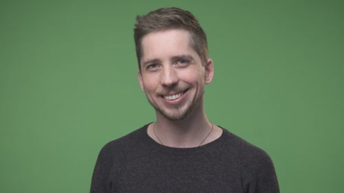Smiling Young Adult in Front of Green Screen