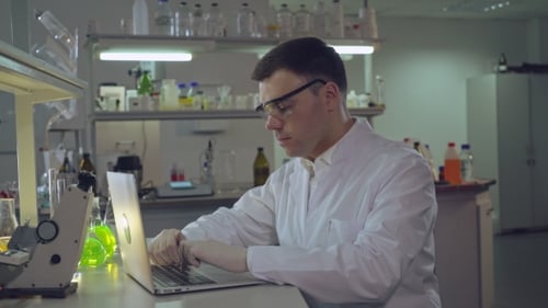 Researcher Working on Laptop in a Laboratory
