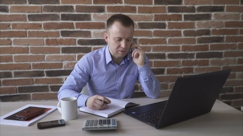 Man Working at His Desk on the Phone