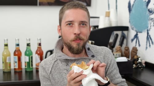 Young Man Eating Burger at Cafe