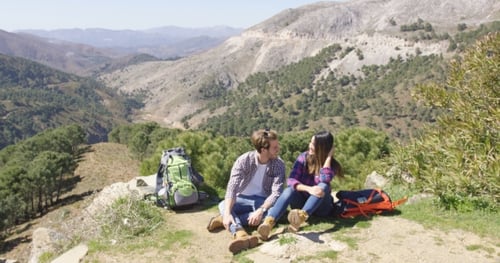 Couple Relaxing on Mountain Hike on Sunny Day