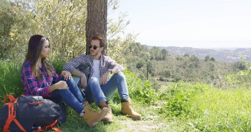 Couple Relaxing Together on Grassy Hillside