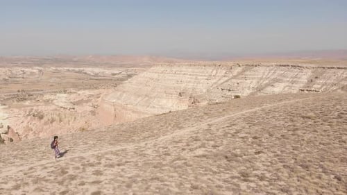 Person Hiking Across Desert Landscape