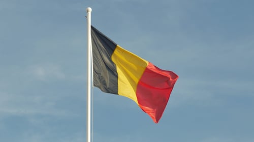 Belgian Flag Waving Proudly Against a Blue Sky