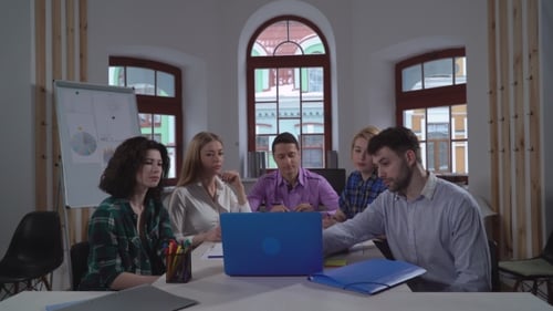 Team Meeting Around Laptop in Modern Office