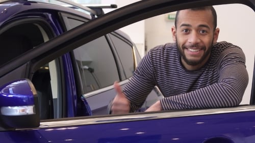 Adult Smiling With a Thumbs Up in a Car