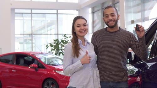 Happy Couple with Car Keys in Showroom