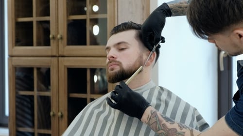 Master Cuts Hair and Beard in the Barber Shop. Cut a Beard with Scissors