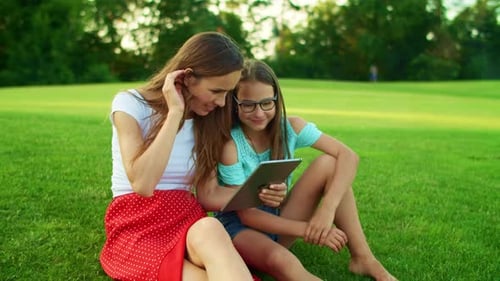 Woman and Girl Use Tablet Outdoors