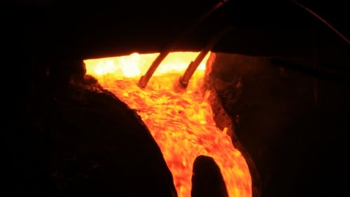 Molten Metal Flowing in a Dark Industrial Setting