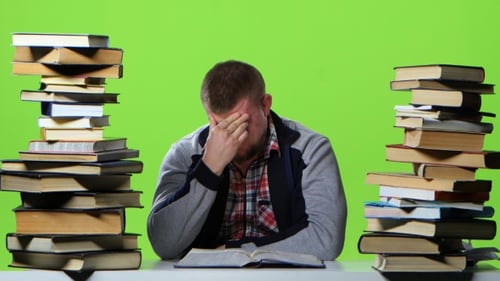 Man Leafing Through a Textbook, It Suffers From Headaches. Green Screen
