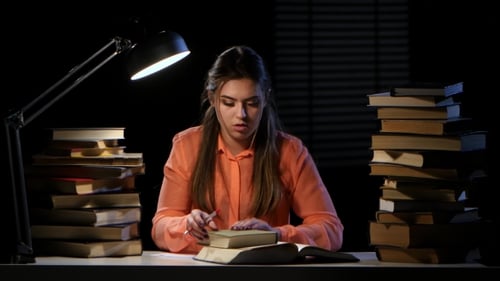 Girl Sits at the Table and Can Not Find the Desired Information. Black Background