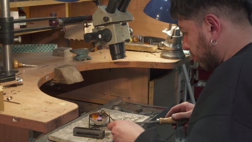 Juwelier lenkt den Gasbrenner in den Tiegel