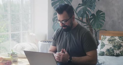 Man Talking at Laptop in Bright Home Office