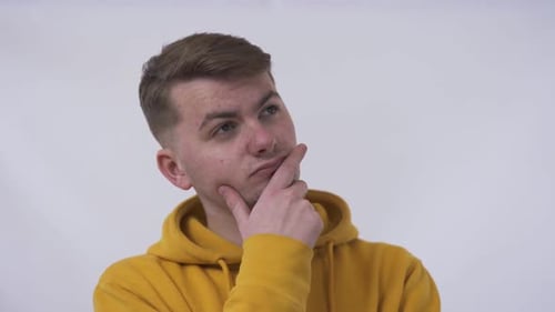 Close-up of a Thoughtful Young Man Looking Away and at the Camera