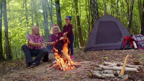 Family Camping Trip Cooking Food over Campfire