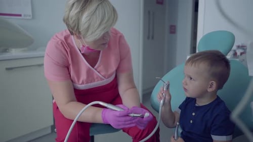 Dentist and Child with Dental Equipment in Clinic