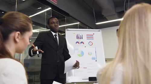 Professional Explains Data in Office Presentation