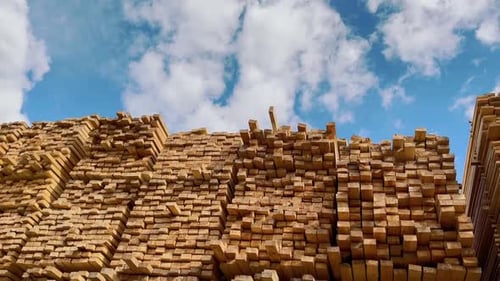 Neatly Stacked Lumber Under a Bright Sky