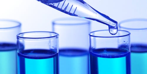 Dropping Liquid into Blue Liquid in Test Tubes