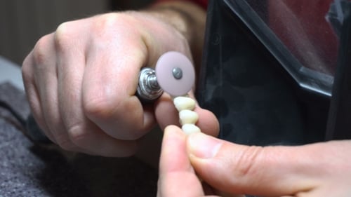 Dentist Using Tool on Dental Piece Close Up