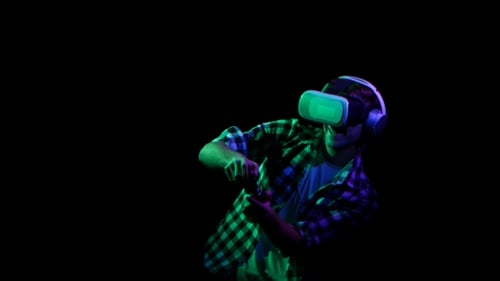 Man Plays on Gamepad in Virtual Reality Glasses. Green Light
