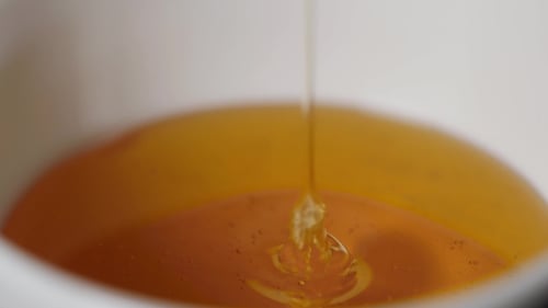 Thin Honey Trickle Against a Black Background