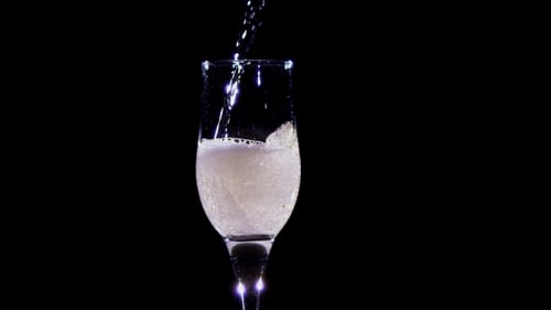 . Champagne Wine Is Poured Into Transparent Glass Tumbler