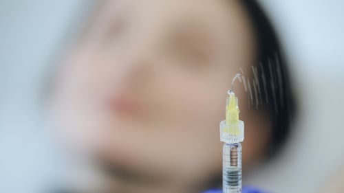 Syringe with Botox in a Front of Woman
