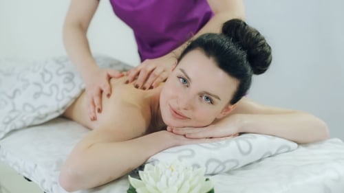 Frau erhält Rückenmassage im Spa