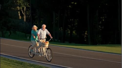 Senior Couple Riding a Tandem Bicycle Together