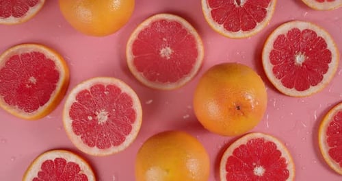 Grapefruit Halves and Whole Fruits on Pink