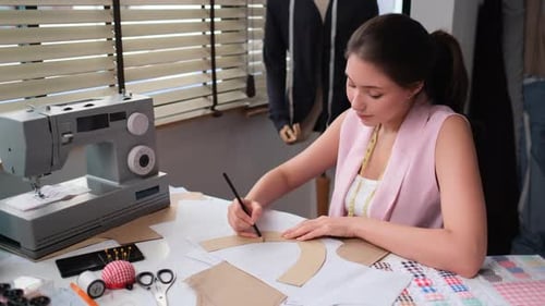 Close up professional woman designer or tailor use pencil draw fashion template on paper