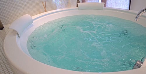 Jacuzzi Tub with Bubbling Blue Water in Modern Bathroom
