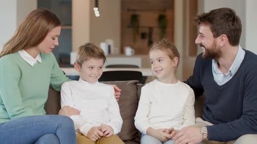 Smiling Family Conversing on Couch in Their Home