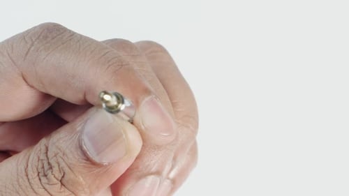 Hand Holding Black and Gold Audio Jack