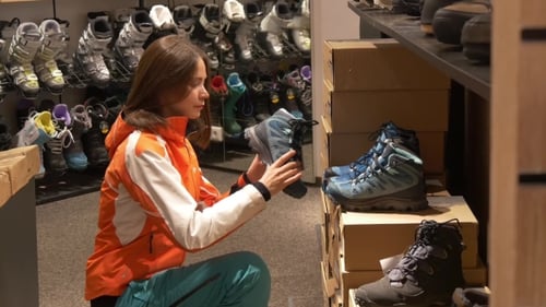 Frau schaut sich Sportschuhe in einem Geschäft an