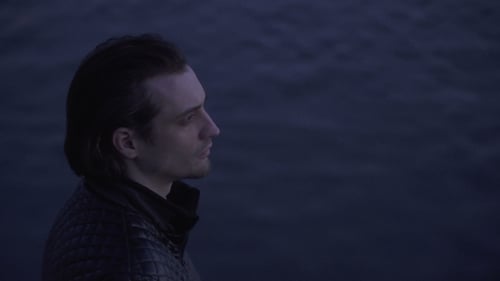 Man Glances at Camera by Dark Water