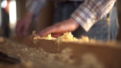 Man Working on a Woodworking Project on a Workbench