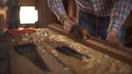 Carpenter Smoothing Wood Plank With Hand Plane