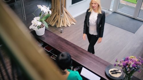 Woman Arriving at Office Reception Desk